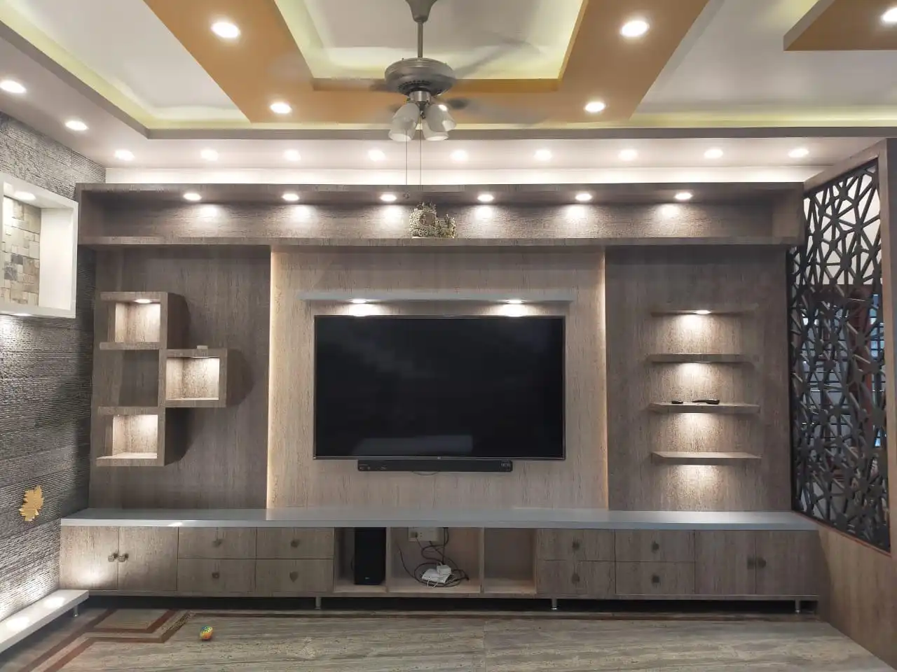 Close-up of a custom TV media wall unit with backlit shelving